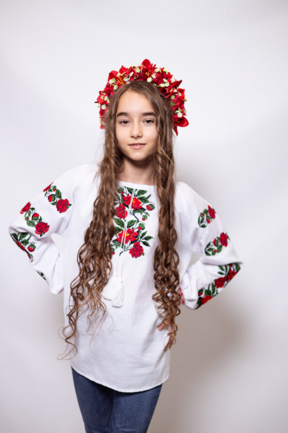Дівчинка у вишиванці з трояндами, у квітковому вінку