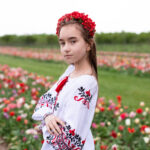Повний вигляд вишиванки на дівчинці серед квіткового поля