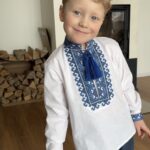 Портрет хлопчика у білій вишиванці з синьою вишивкою та китицями